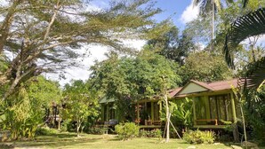 Un resort tropical con varias cabañas de madera rodeadas de exuberante vegetación.