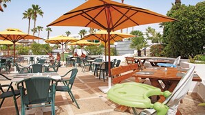 Outdoor seating with umbrellas, tables, and chairs.