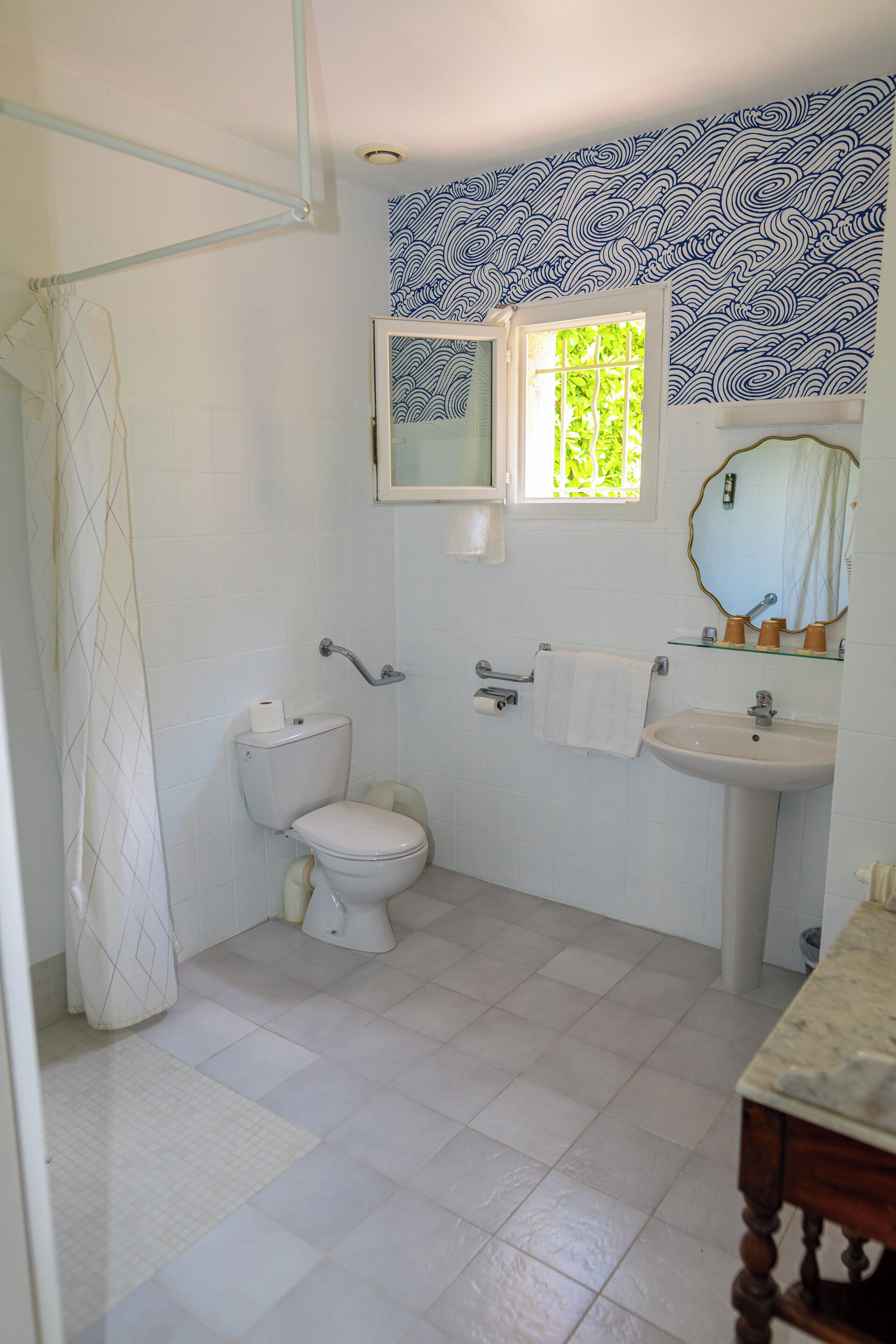 A bathroom with a toilet, sink, and shower curtain.