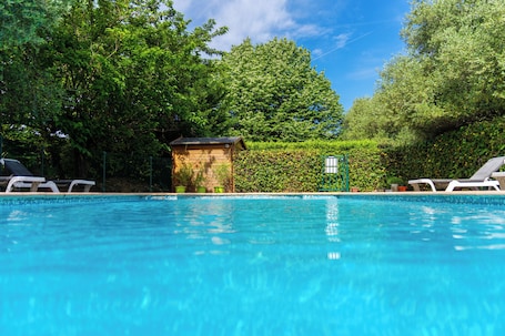 Una piscina al aire libre, sillones reclinables de piscina