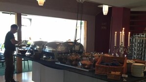 A room with a large window, a bed, a dresser, and a mirror. - Piteå Golfhotell (Pitea)
