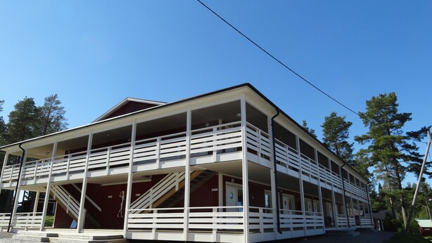 A two-story building with a balcony on the ground floor and a staircase leading to the upper floor. - Piteå Golfhotell (Pitea)