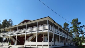 Ein zweistöckiges Gebäude mit einem Balkon im Erdgeschoss und einer Treppe zum Obergeschoss.