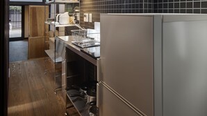 A modern kitchen with stainless steel appliances, black tiled backsplash, and wooden flooring. - Kiyomizu Gojo Ntei (Kyoto)