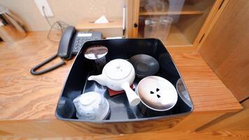 Una bandeja con teteras y tazas sobre una mesa de madera.