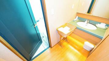 A compact bathroom with a sink, mirror, and a small wicker basket.