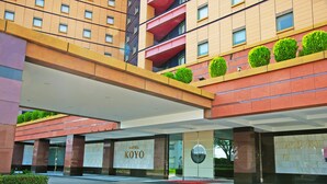 A hotel entrance with a modern design, featuring a prominent 'HOTEL KOYO' sign, a covered walkway, and a landscaped area with neatly trimmed bushes. - Hotel KOYO (Hashima)