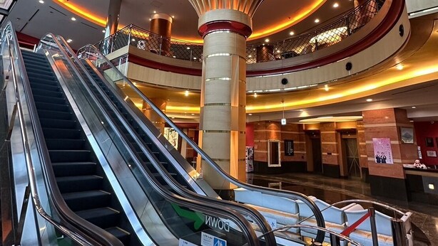A modern interior with multiple levels, escalators, and a central column with a unique design. - Hotel KOYO (Hashima)