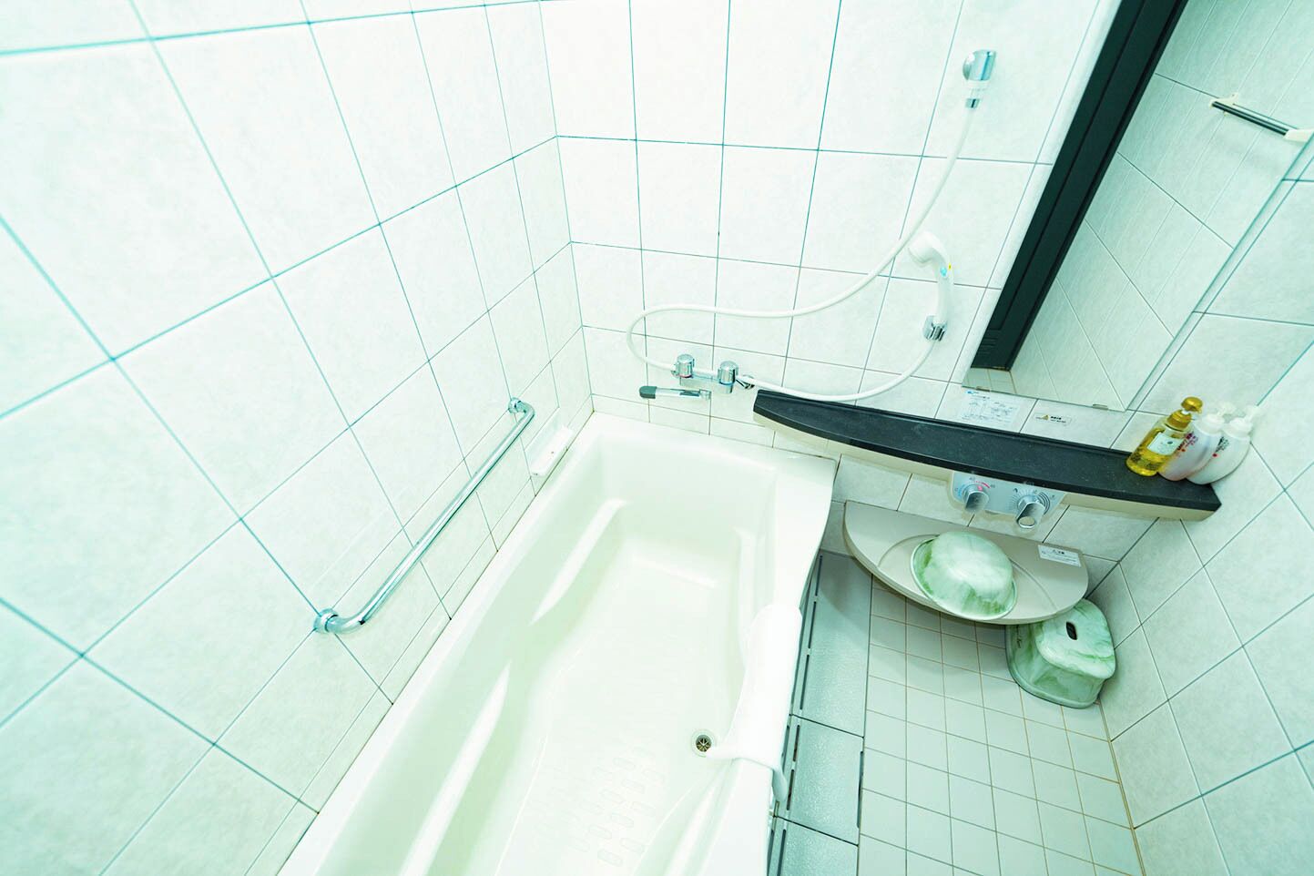 A bathroom with a bathtub, a sink, a mirror, and a toilet.