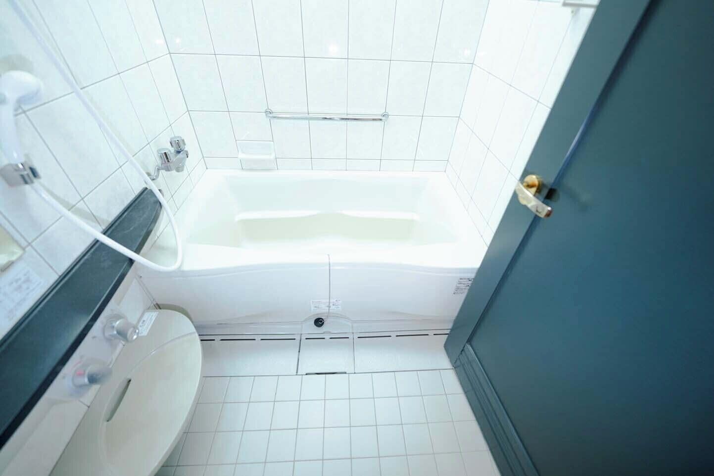 Un baño con una bañera blanca, un inodoro y un lavamanos.