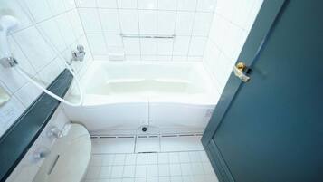 A bathroom with a white bathtub, a toilet, and a sink.