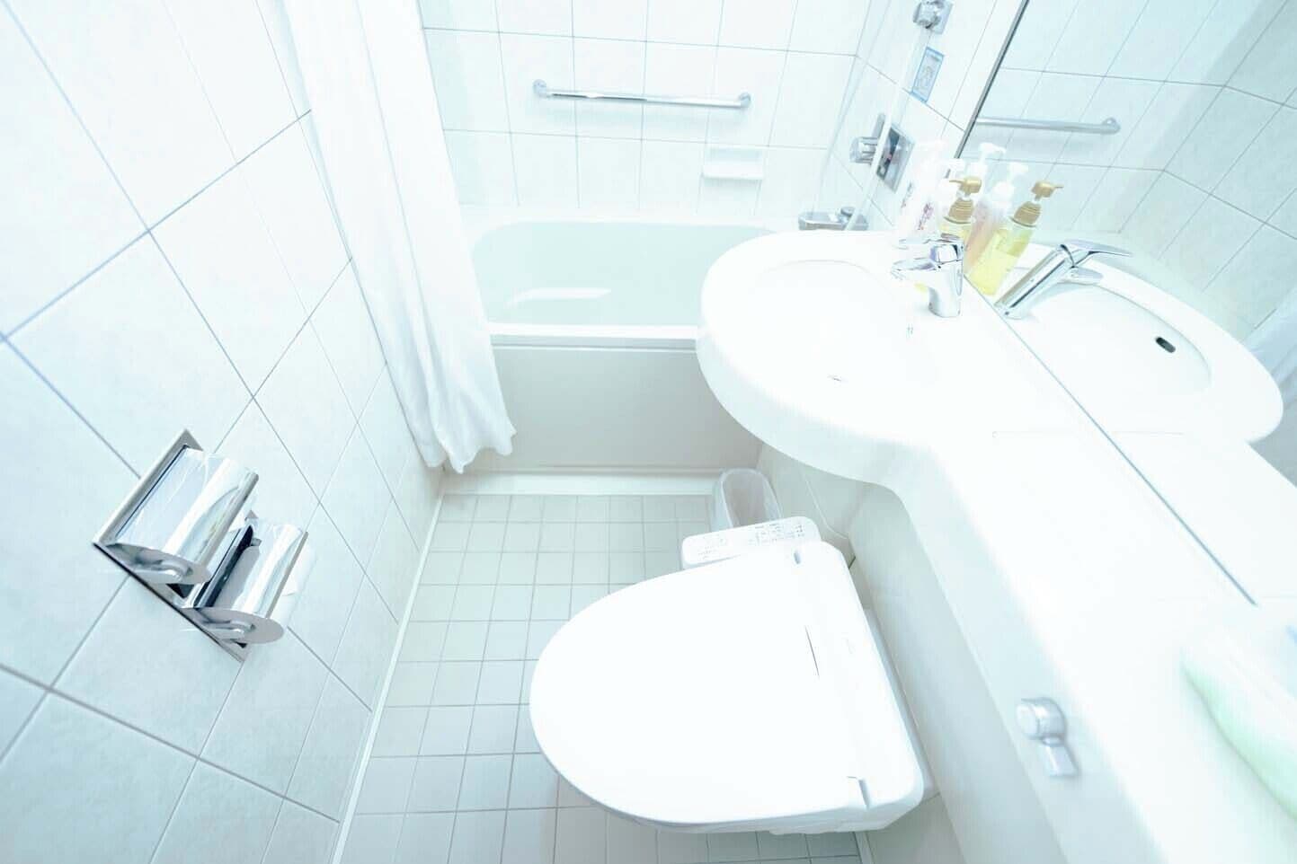 A bathroom with a white toilet, a sink, a bathtub, and a shower.
