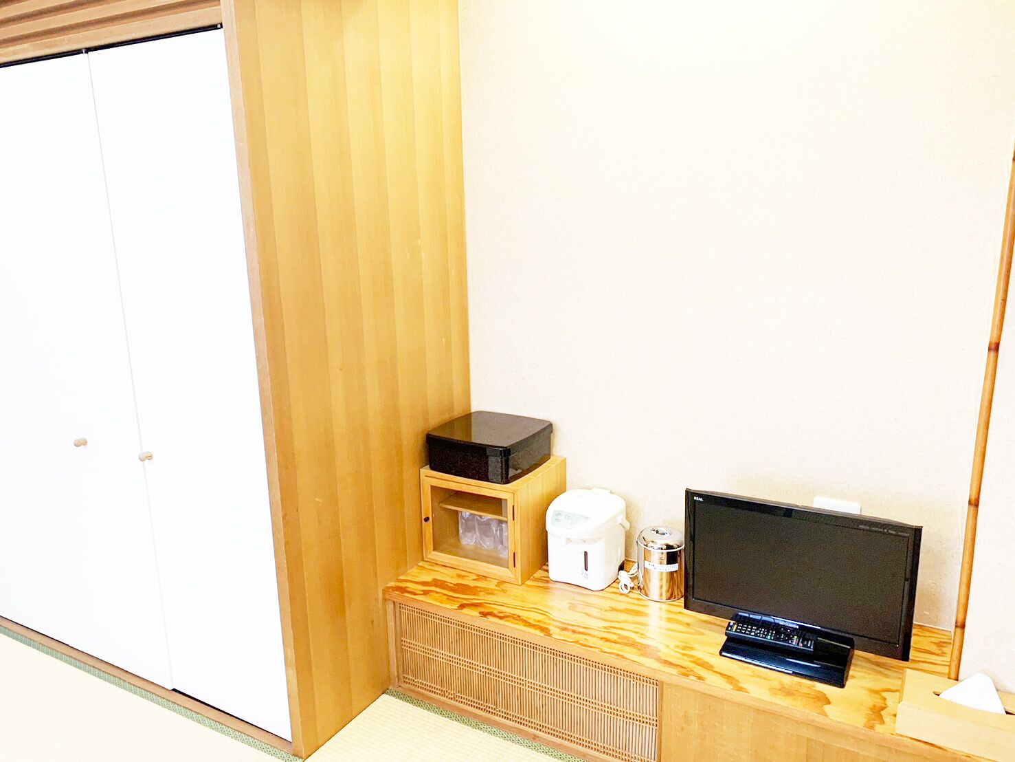 Ein Zimmer mit einem Holzkasten, einem Fernseher und einer Kaffeemaschine.