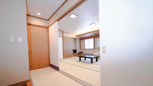 A room with tatami flooring, a sliding door, a bed, a TV, and a window. - Hotel KOYO (Hashima)