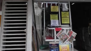 Segnale per IORA DAMAI INN con vetrina che espone riviste e una porta ben visibile.