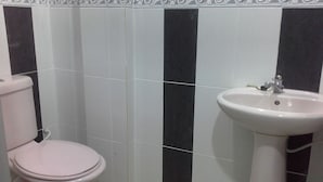 Un bagno con il water e un lavandino, separati da piastrelle bianche e nere.