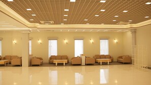 A spacious lobby with a polished floor, multiple sofas arranged in rows, and recessed ceiling lighting. - Hotel Dolphin (Kanthi)