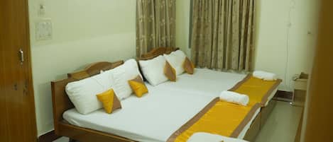 Una cama doble con estructura de madera, ropa de cama blanca y dos almohadas amarillas.