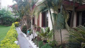 A building with a well-maintained garden, a staircase, and a pathway.
