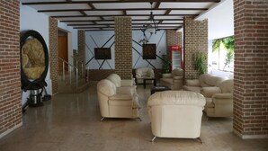 A spacious lobby with a high ceiling, brick walls, and multiple seating areas. - Maren Beach Apart (Alanya)