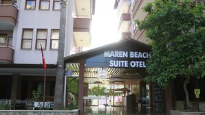 The exterior of Maren Beach Suite Hotel with a covered entrance, stone steps, and a signboard. - Maren Beach Apart (Alanya)