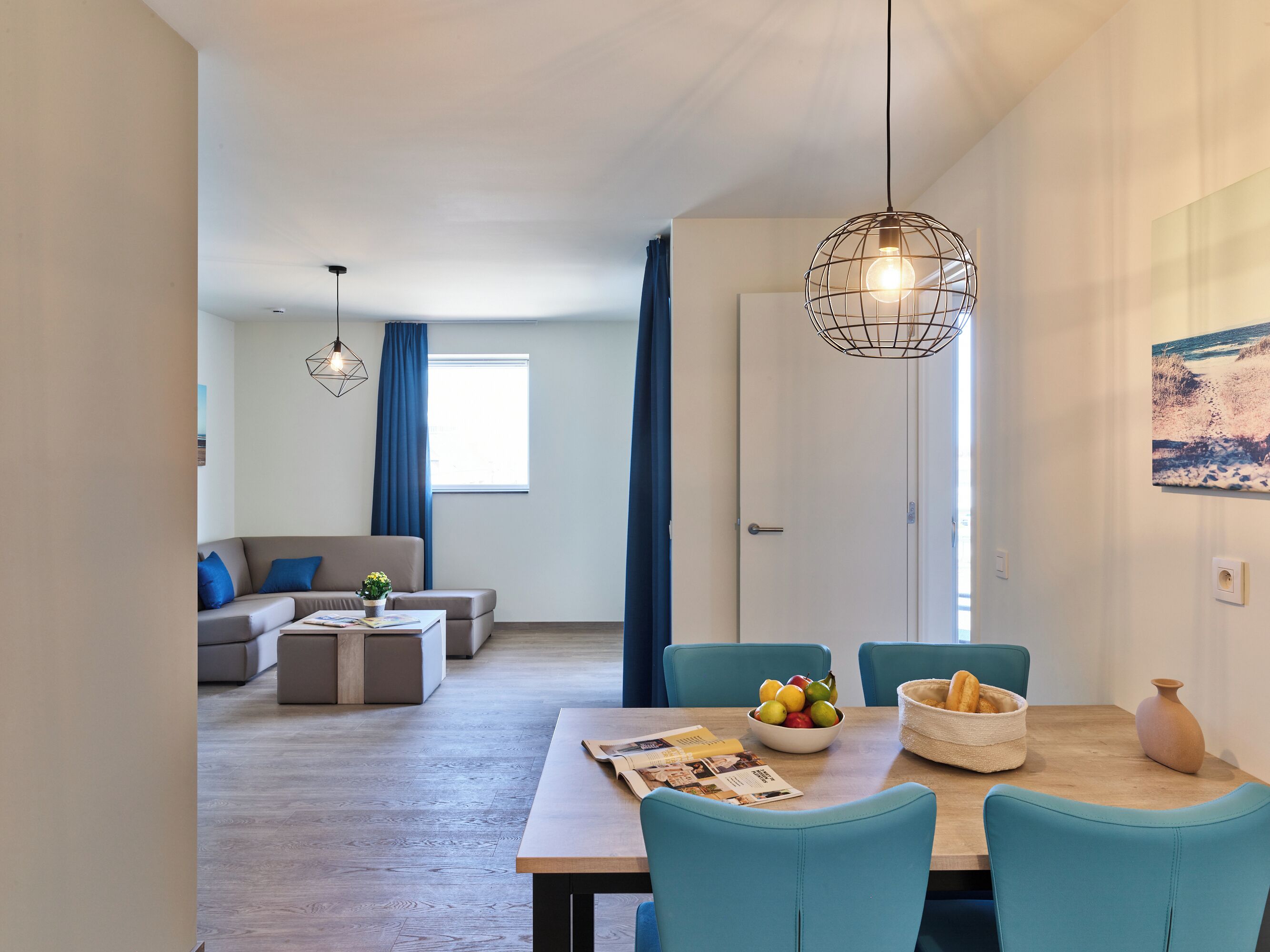 Ein modernes Wohnzimmer mit einer Couch, einem Couchtisch und einem Essbereich mit Stühlen und einem Tisch.
