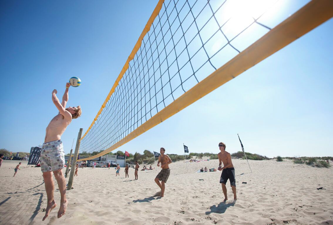 Ein Beachvolleyballspiel mit Spielern und Netz.