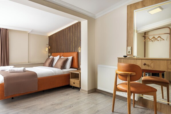 A modern bedroom with a bed, nightstand, chair, dresser, and mirror.
