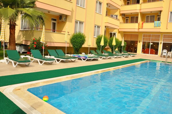 Alberca al aire libre, sombrillas en la alberca y camastros 