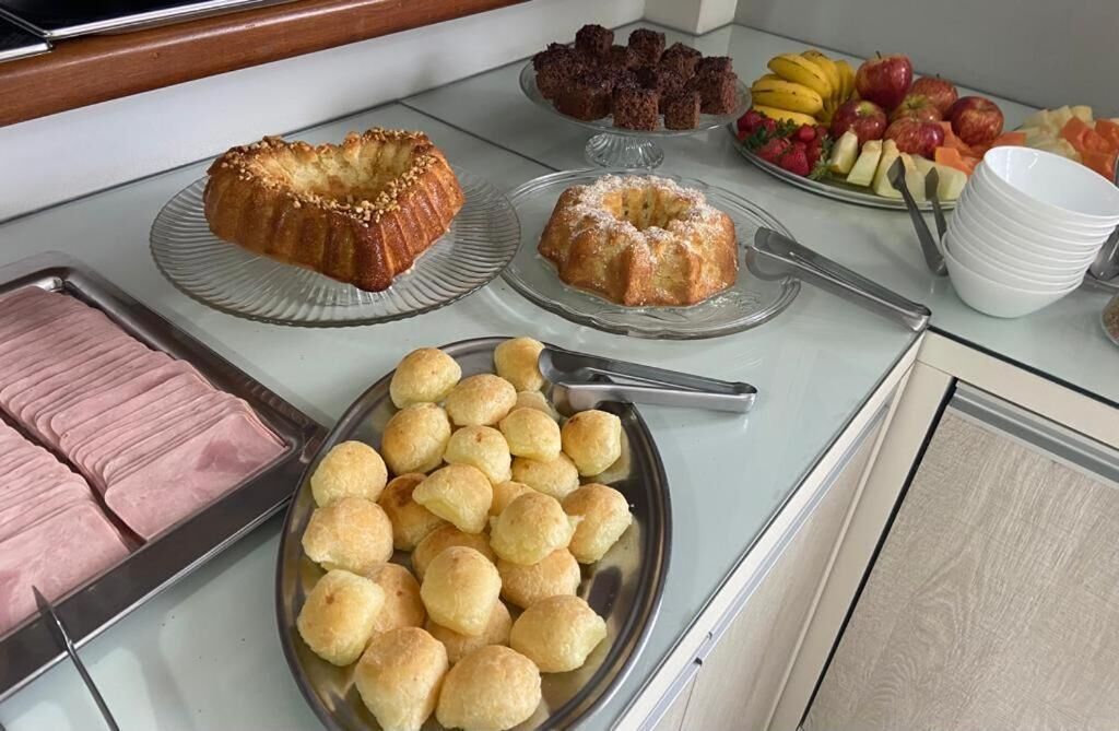 A buffet table with various food items including cakes, pastries, and fruits.