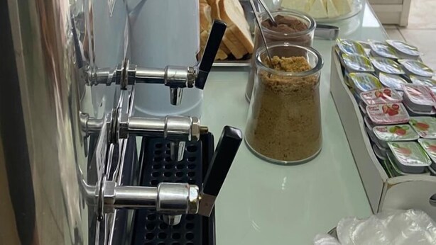 Un buffet proposant une variété de plats, une machine à café et des condiments.