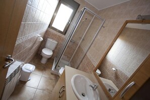 A bathroom with a shower, toilet, and sink.