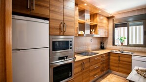 Eine moderne Küche mit Holzausstattung, Edelstahlgeräten und einem Fenster mit Pflanze.