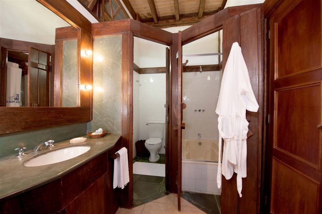 A bathroom with a wooden vanity, a large mirror, a bathtub, and a shower.