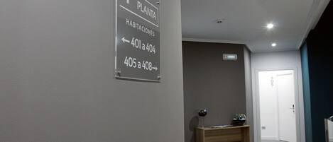 A hallway with a sign indicating room numbers and directions to the plant area.