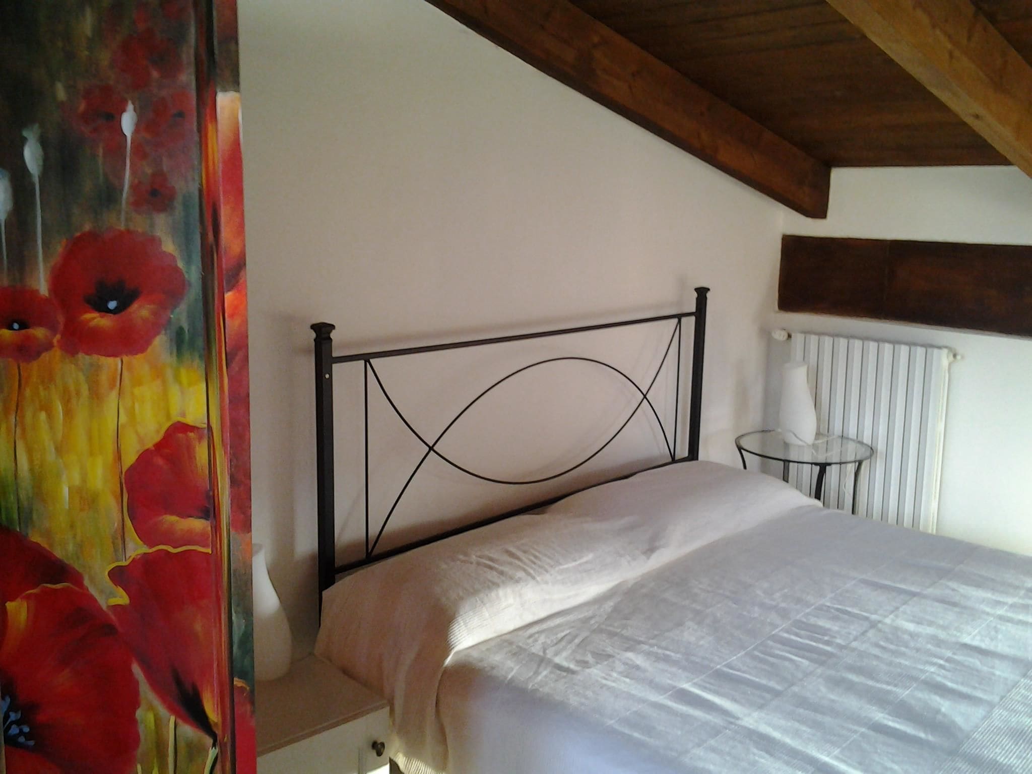 Ein Schlafzimmer mit einem Bett, einem Heizkörper und einem kleinen Tisch.