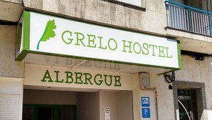 Et hostel kaldet "Grelo Hostel" med en grøn blad-logo, beliggende i Albergue.