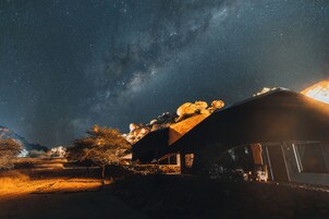 Un paisaje rural con una casa bajo un cielo estrellado.