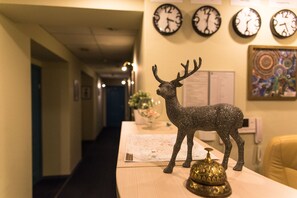 Enter a welcoming space with a long corridor leading to our reception area, featuring a reception desk and a beautiful abstract painting.