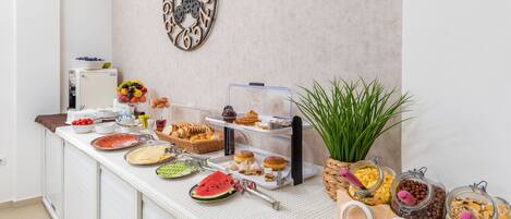 A buffet setup with various food items and a decorative wall clock.