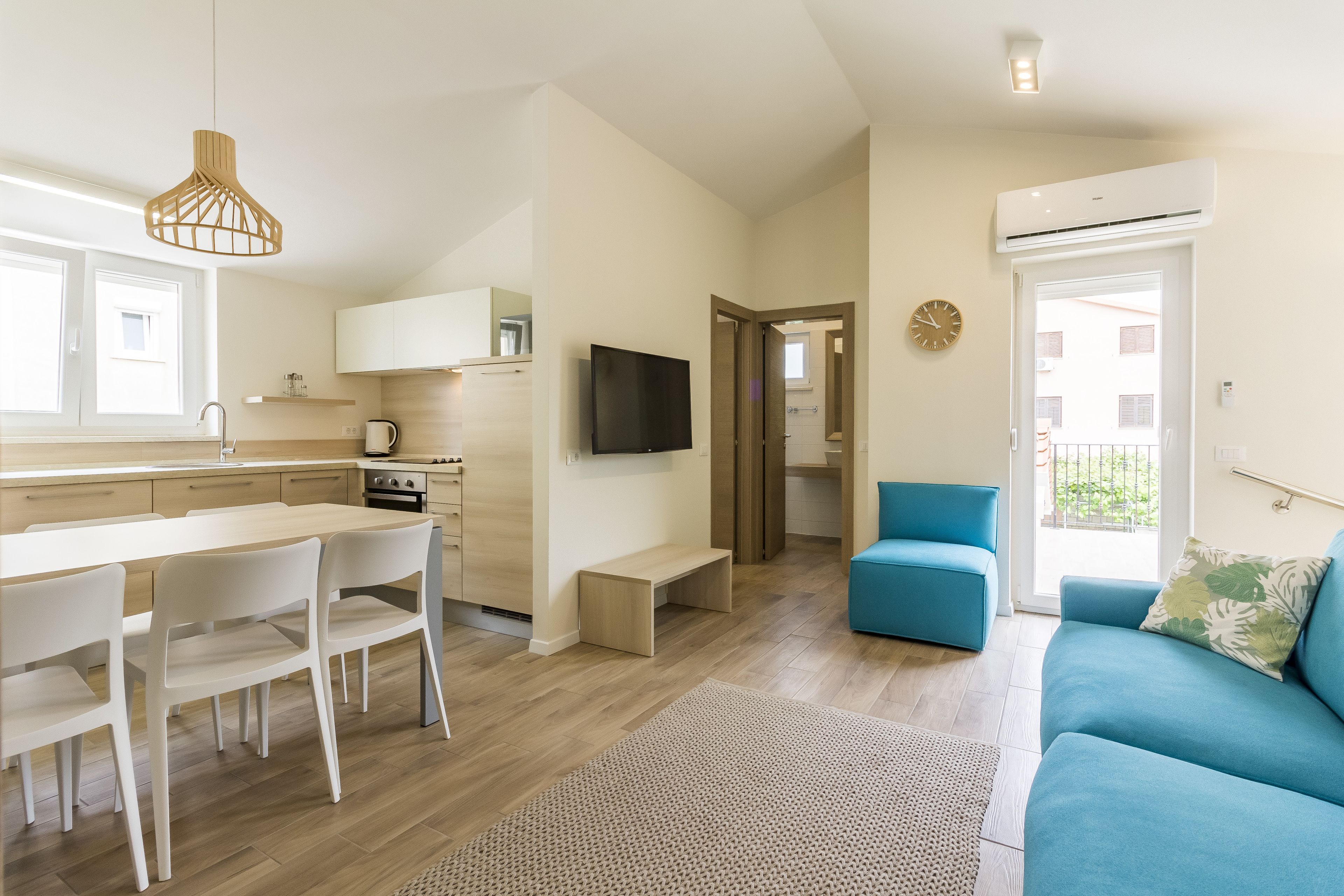 A modern apartment with a kitchen, dining area, and living room.