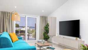 A modern living room with a sofa, coffee table, and a flat-screen TV.