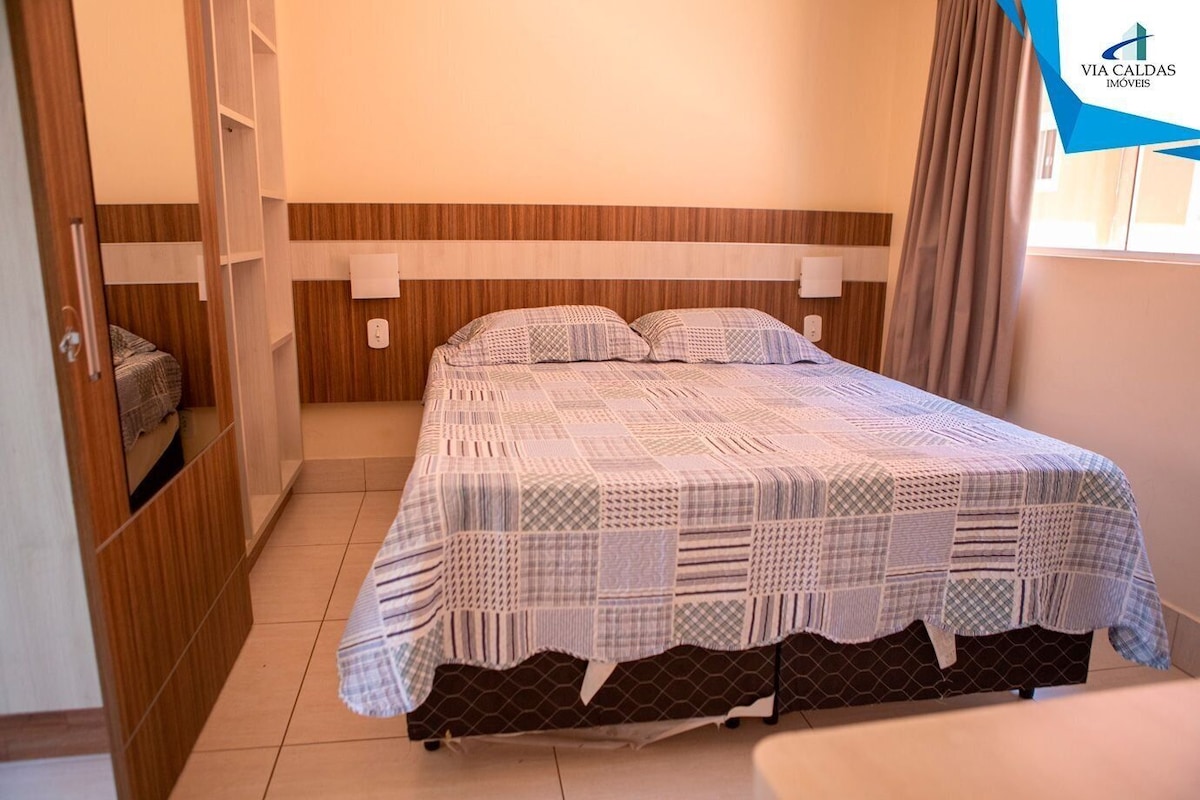 Un dormitorio con cama, armario y ventana.