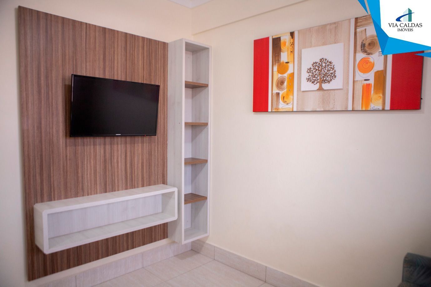 Ein modernes Wohnzimmer mit Flachbildfernseher an einer Wand aus Holzpaneelen, einer eingebauten weißen Unterhaltungseinheit und einem dekorativen Wandbild.