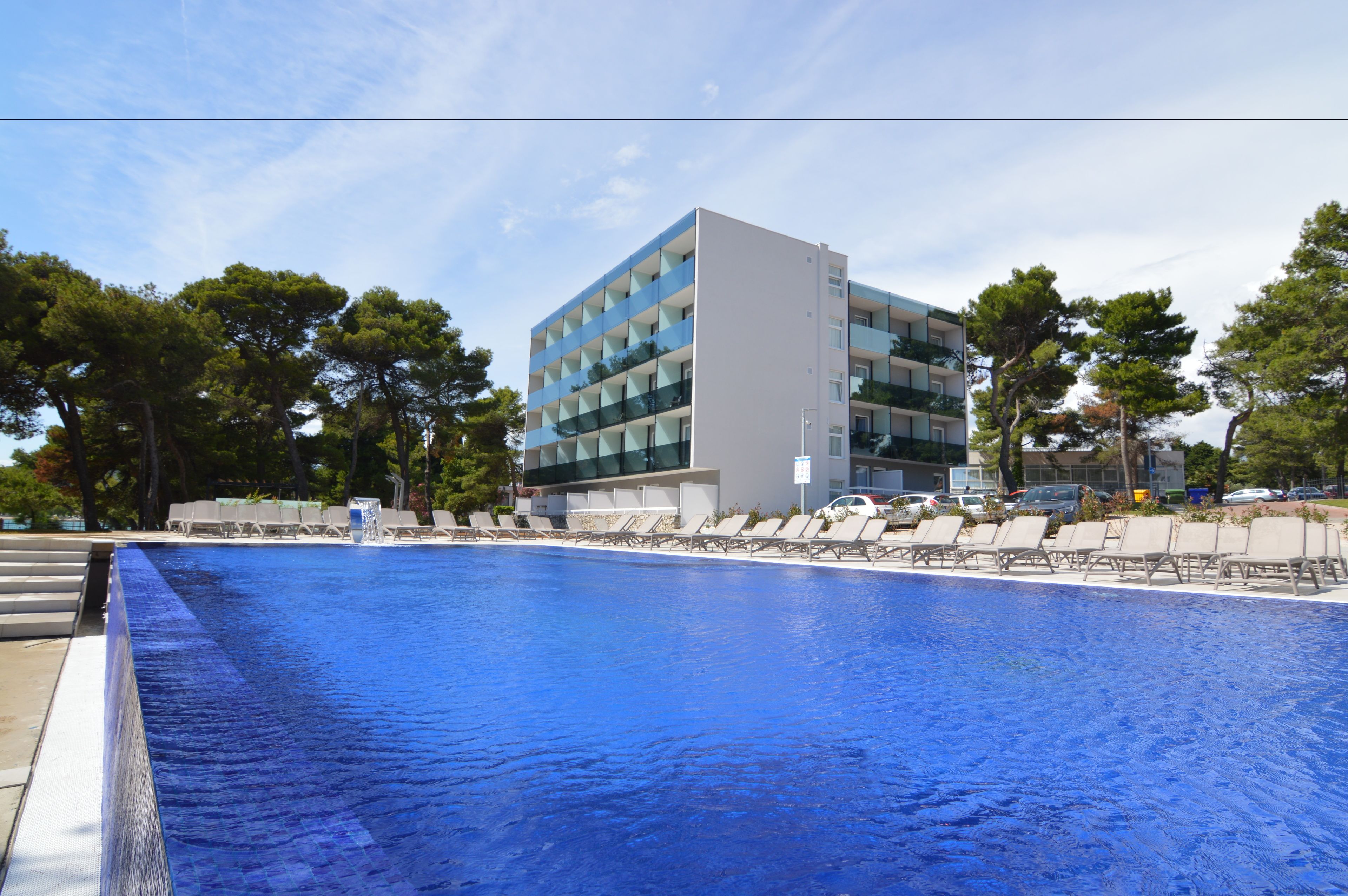 Un edificio moderno con una piscina di fronte.