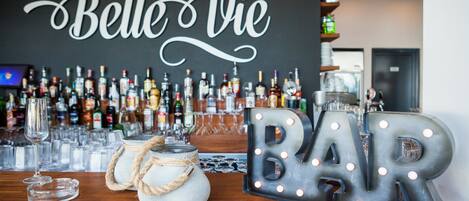 A bar area with a sign reading "la Belle Vie" and illuminated letters spelling "BAR".