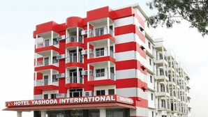 Un immeuble hôtelier à plusieurs étages, doté de balcons et d’une enseigne indiquant « Hôtel Yashoda International ».