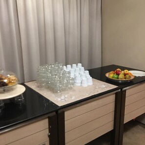 A hotel room with a black countertop, a plate of fruit, and a pile of white cups. - De Wapser Herberg (Wapse)