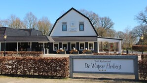 A hotel restaurant named De Waspers Herberg with a classic architectural style, a covered outdoor seating area, and a sign indicating a 3-star rating. - De Wapser Herberg (Wapse)