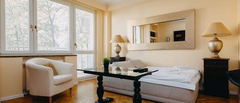 A hotel room with a bed, a desk, a chair, and a large window.